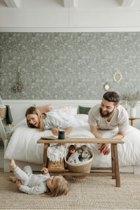 a couple with their child playing in bedroom